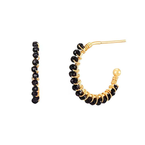 Gold hoop earrings with black beads on a white background