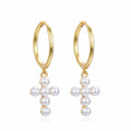 Gold hoop earrings with pearl cross designs on a white background