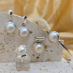 Pearl earring set on a stone display block with a soft background