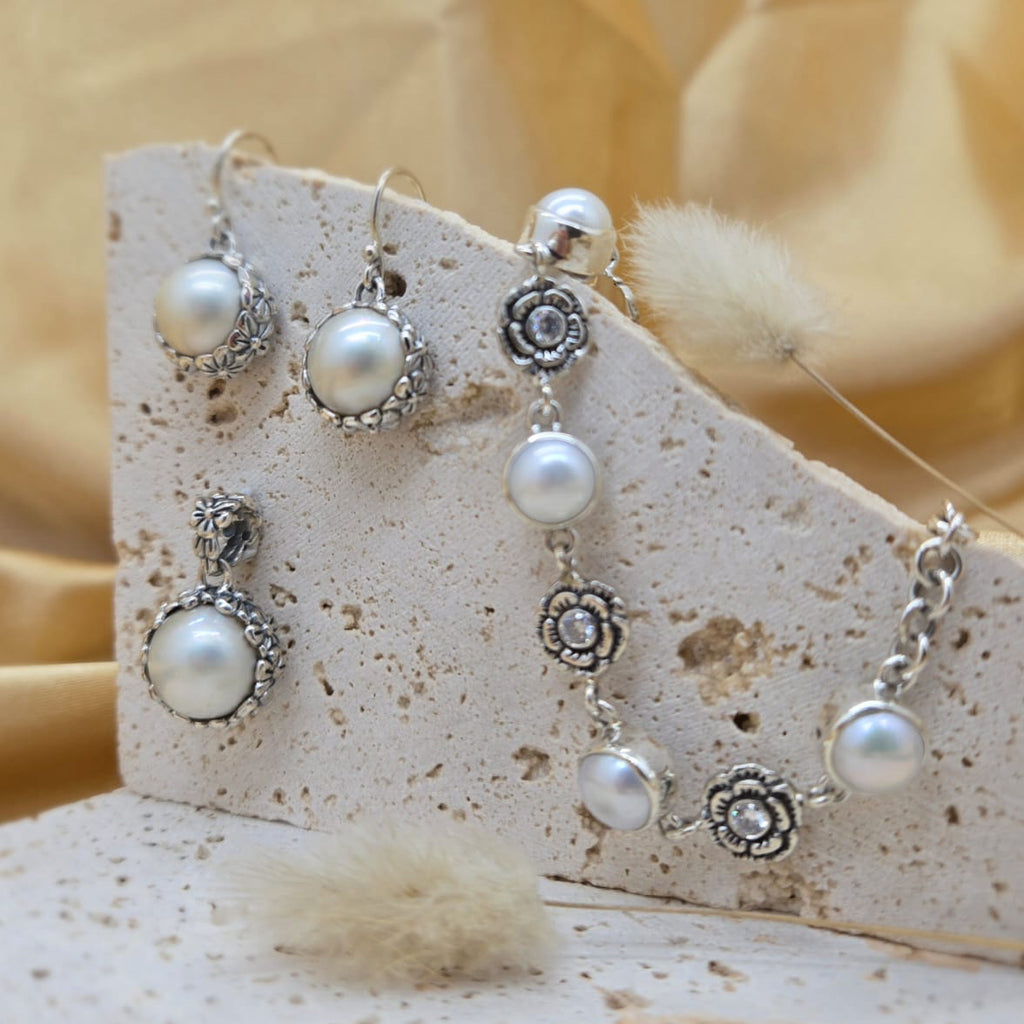 Set of pearl and silver earrings on a decorative card with a soft focus background