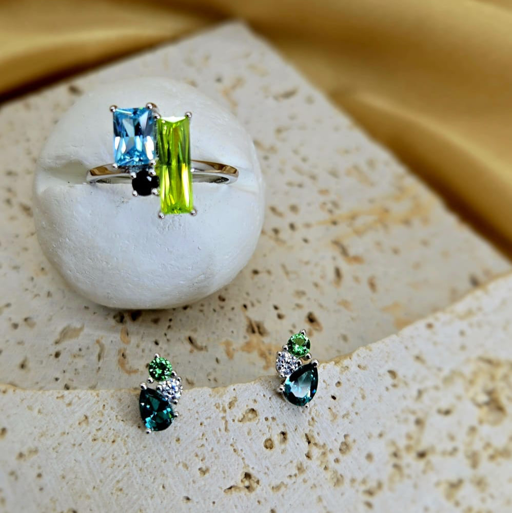 Ring and earrings with gemstones on a textured surface