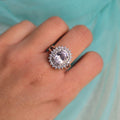 Silver ring with a large diamond on a hand against a light blue background