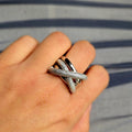 Silver ring on a person's finger with a striped background