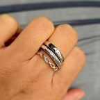 Hand wearing multiple rings with a blurred background