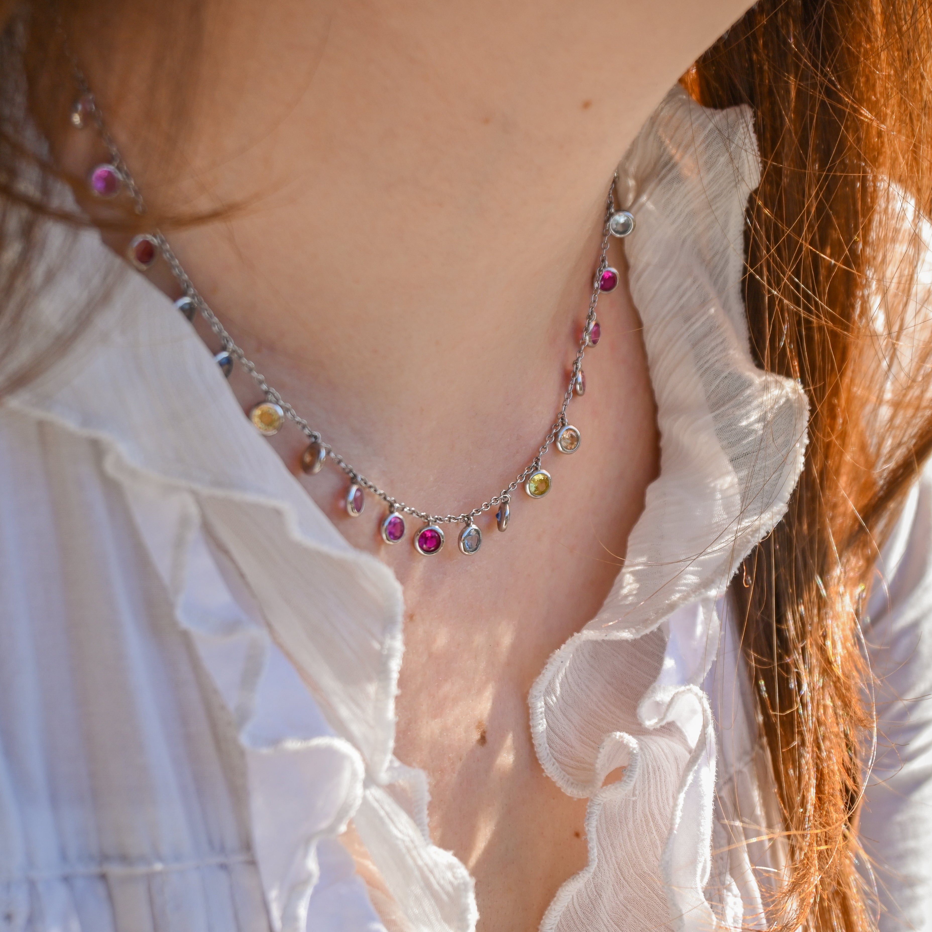 Close-up of a person wearing a colorful necklace with a blurred background
