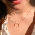 Close-up of a person wearing a silver necklace with circular pendants.