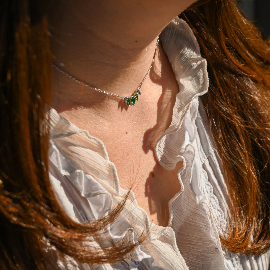 Close-up of a person wearing a white blouse with ruffled details, with a blurred background.