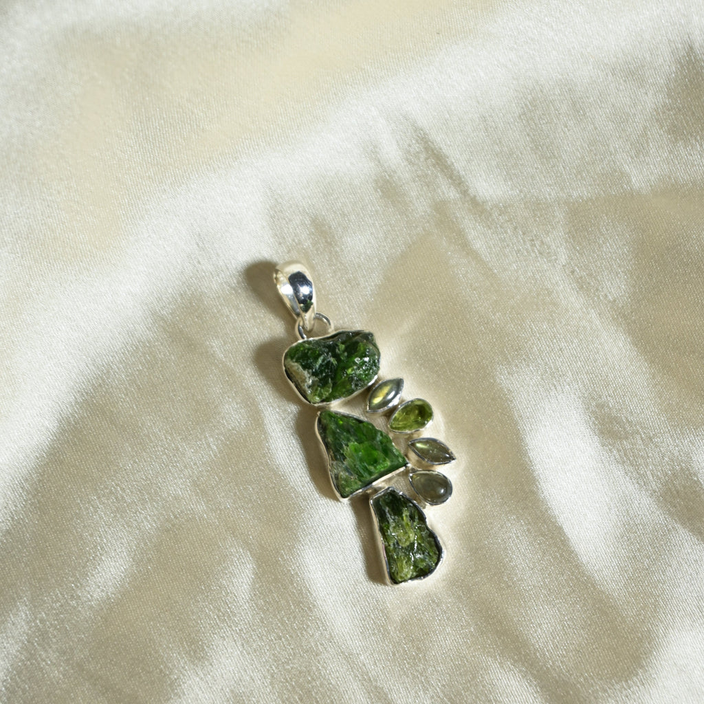 Green stone pendant on a white fabric background