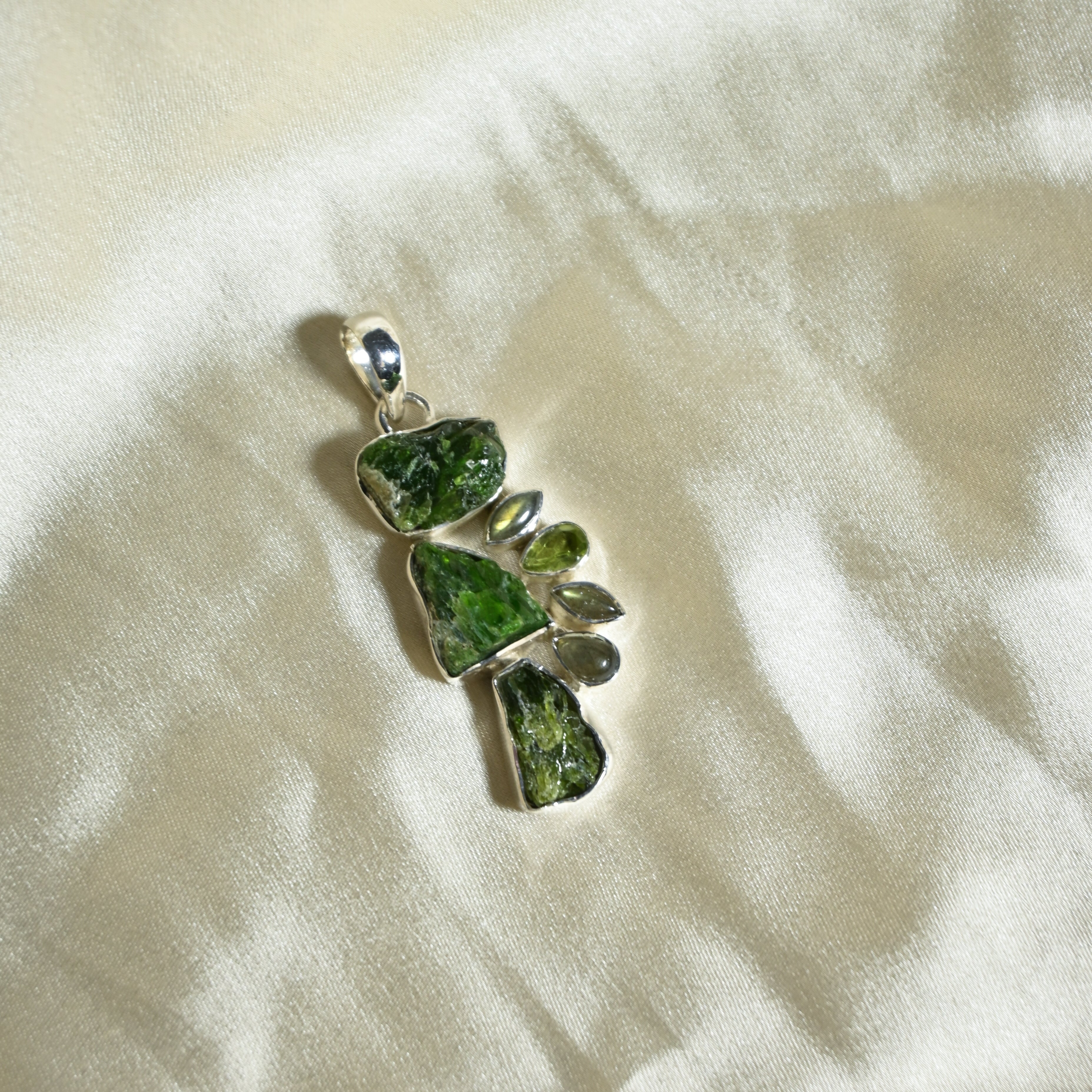 Green stone pendant on a white fabric background
