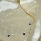 Close-up of a beige fabric with a decorative chain and stones.