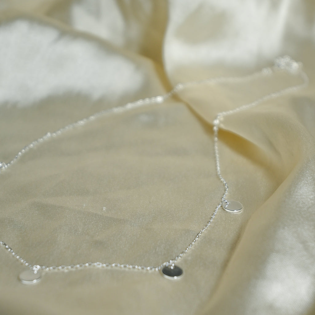 Close-up of satin fabric with a droplet on it