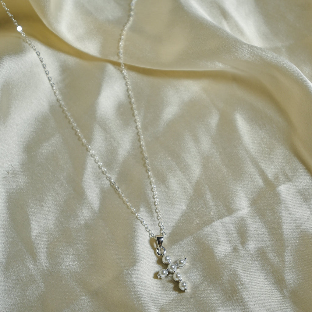 Necklace with a small pendant on a light fabric background