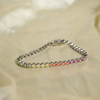 Silver bracelet with colorful beads on a beige fabric background