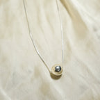 Necklace with a pendant on a beige fabric background
