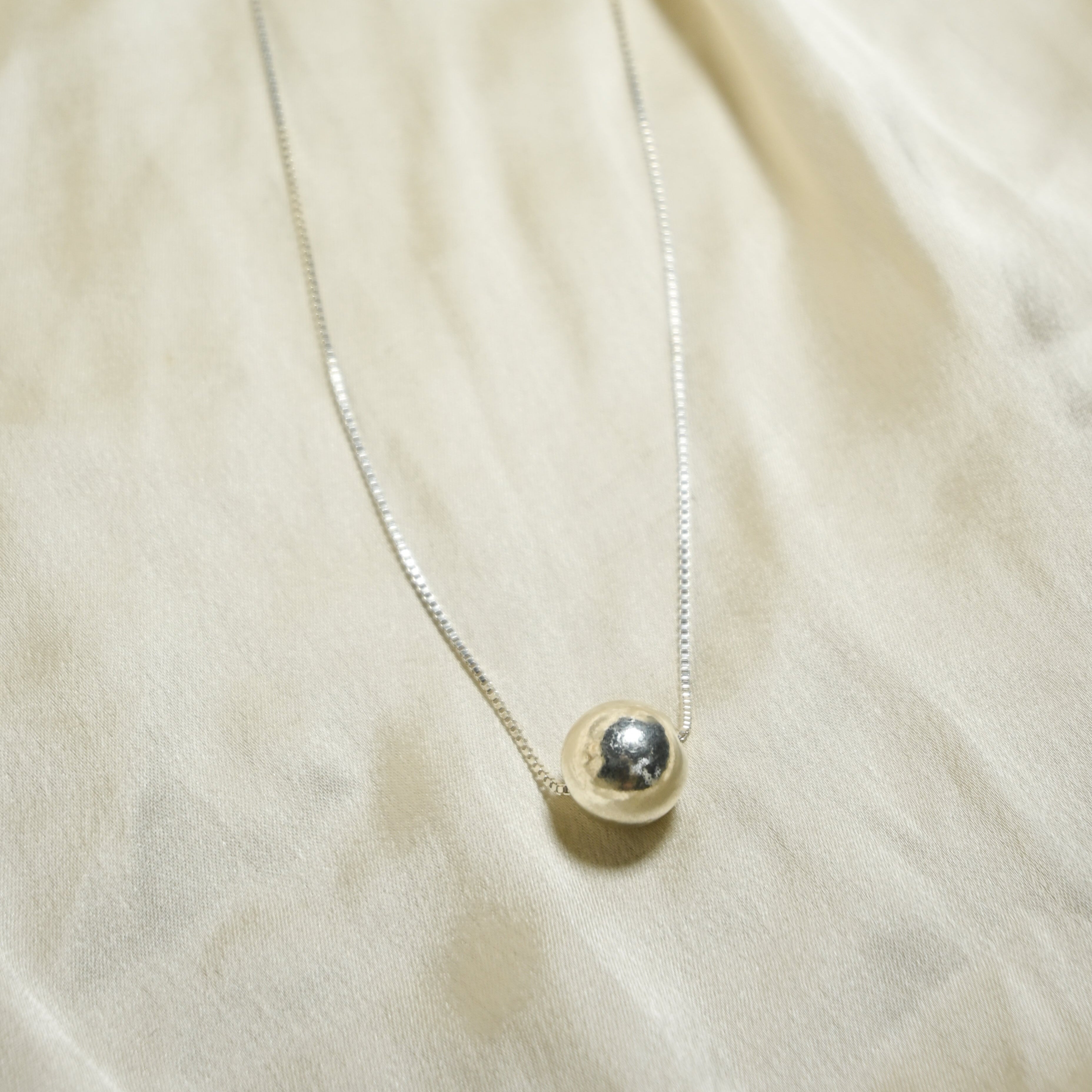 Necklace with a pendant on a beige fabric background
