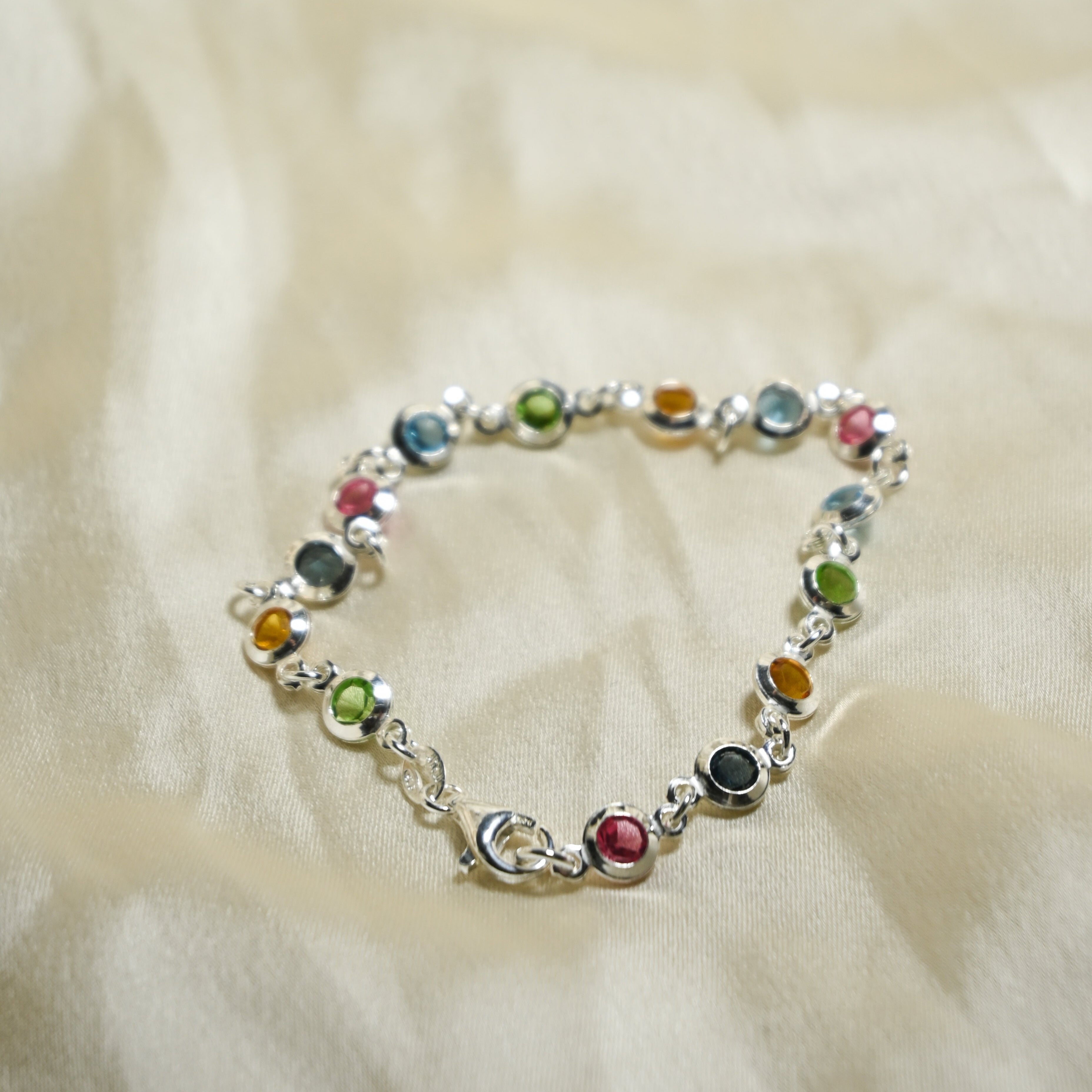 Multicolored beaded bracelet on a soft beige fabric background