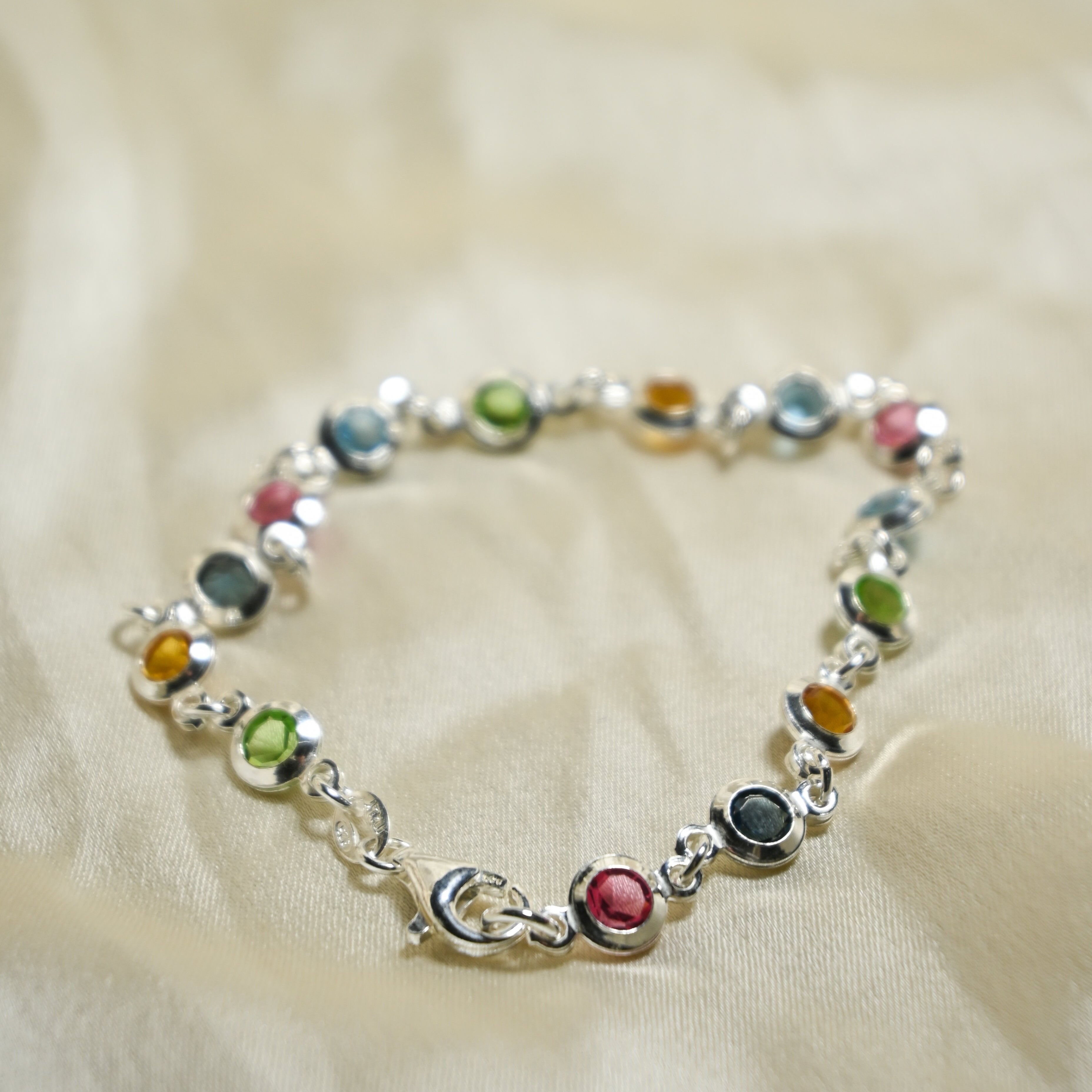 Multicolored beaded bracelet on a beige fabric background