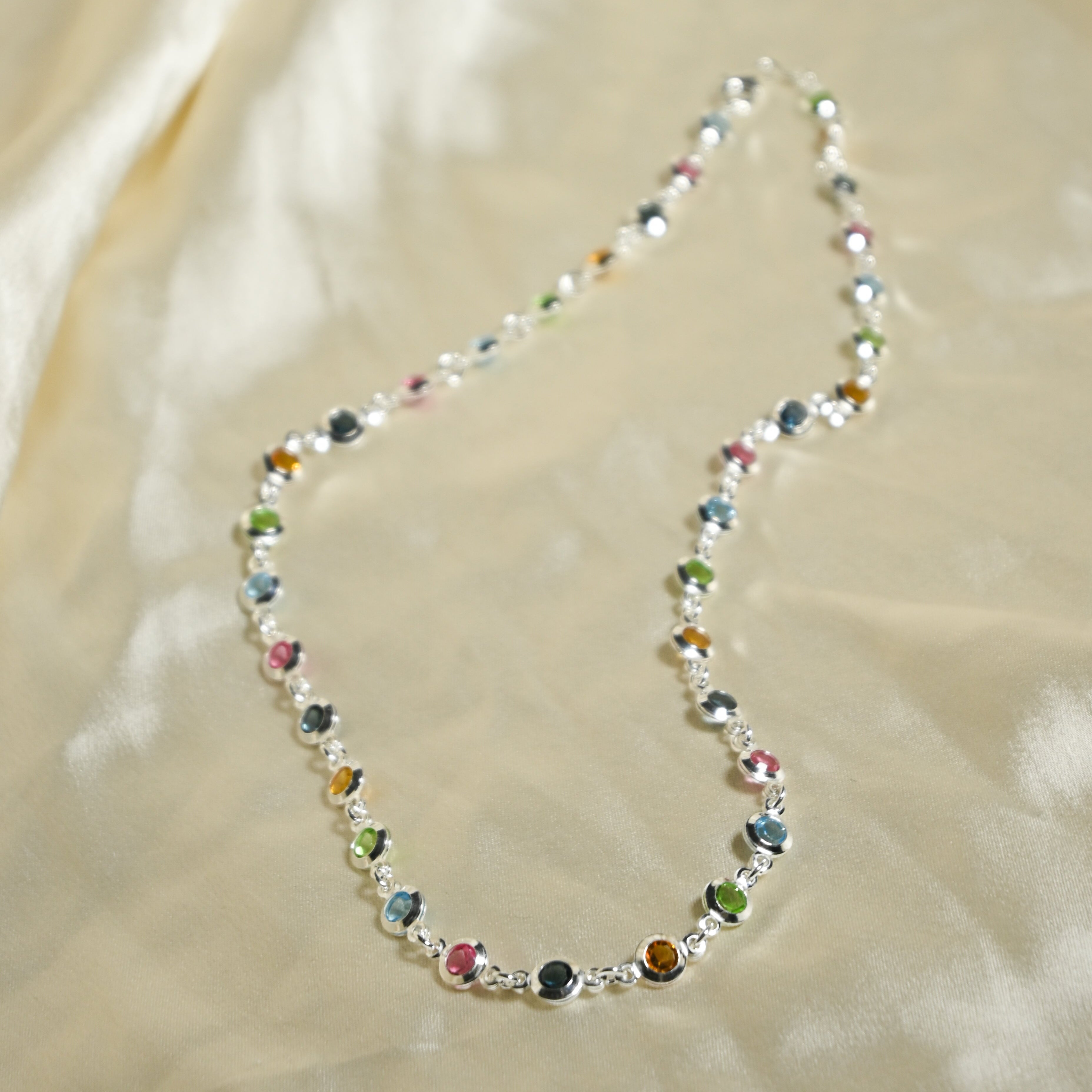 Necklace with multicolored beads on a beige fabric background