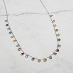 Necklace with colorful gemstones on a beige fabric background