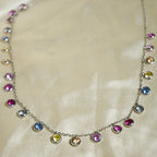 Necklace with multicolored gemstones on a beige fabric background
