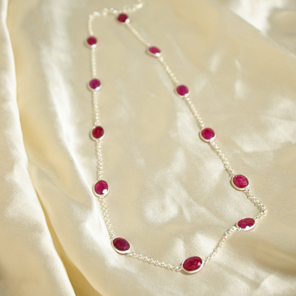 Necklace with red stones on a beige fabric background