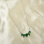 Necklace with green gemstones on a beige fabric background