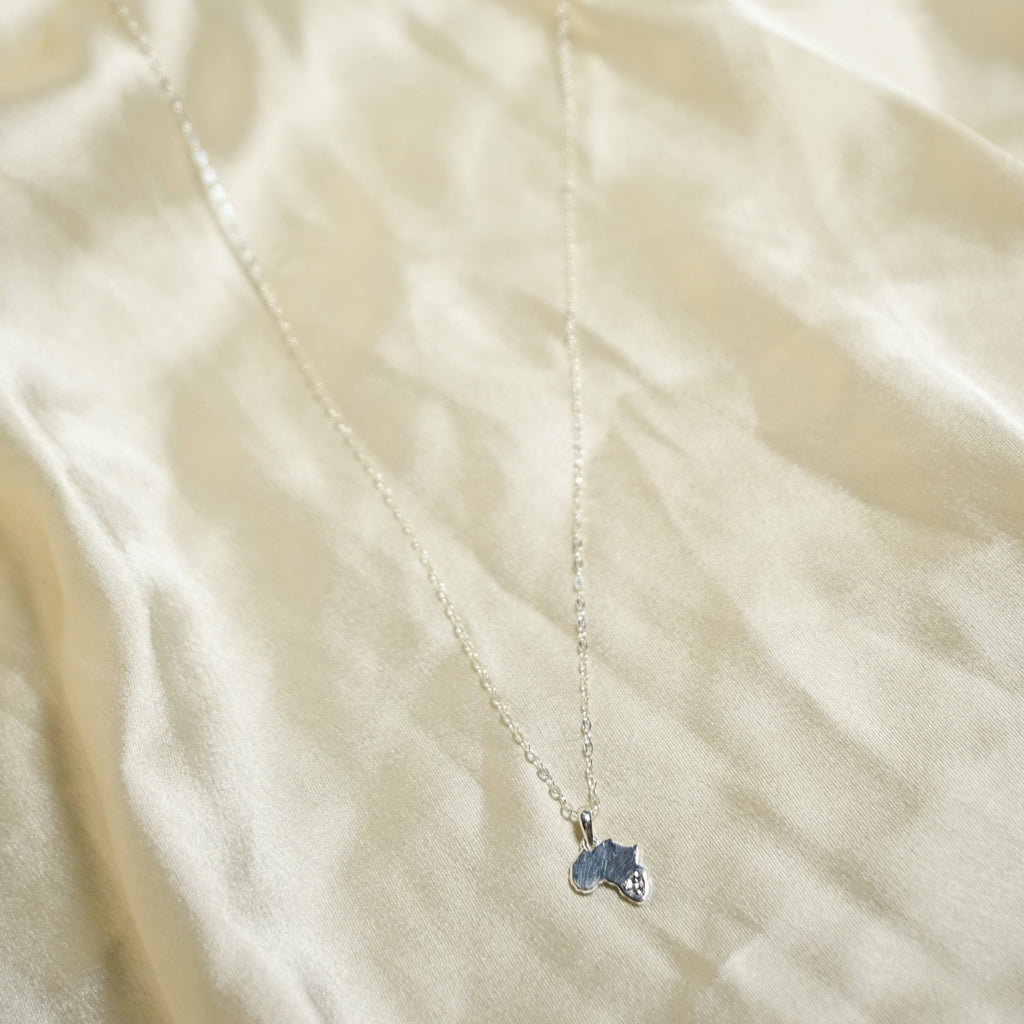 Necklace with a blue pendant on a beige fabric background