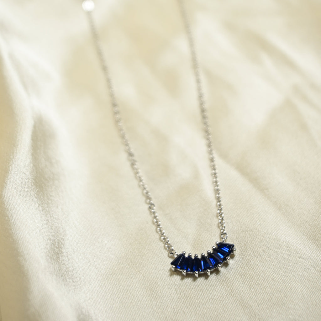 Necklace with blue gemstones on a beige fabric background