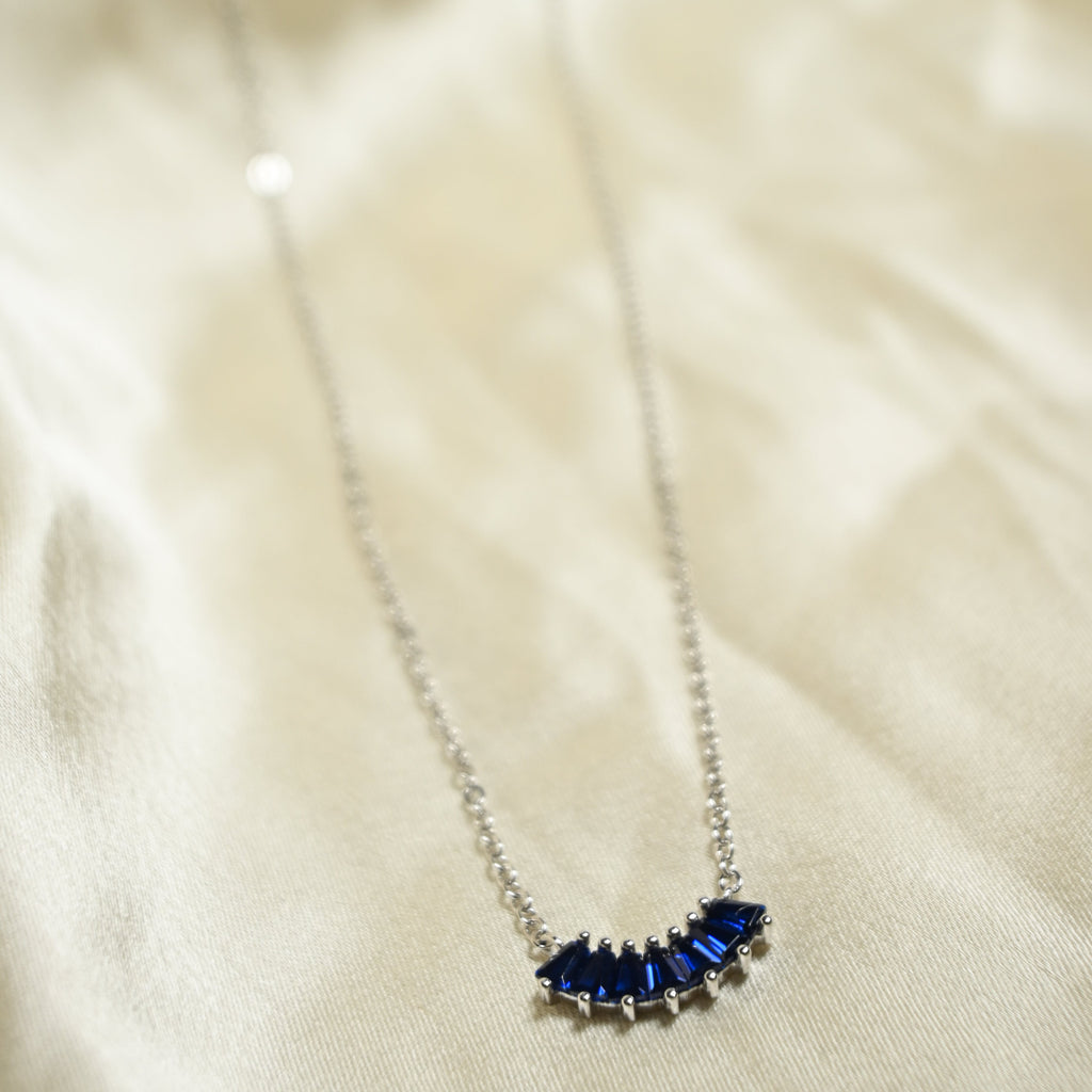 Necklace with blue gemstones on a beige fabric background