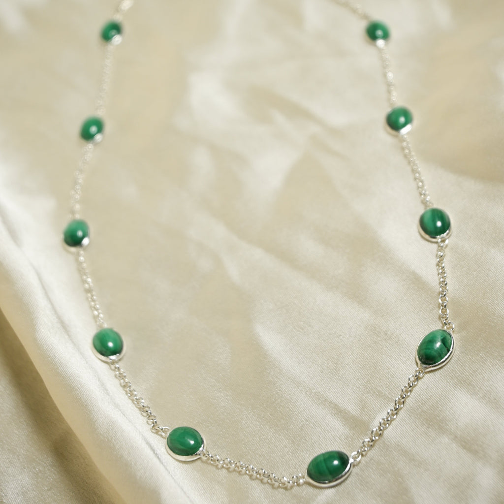 Necklace with green beads on a beige fabric background
