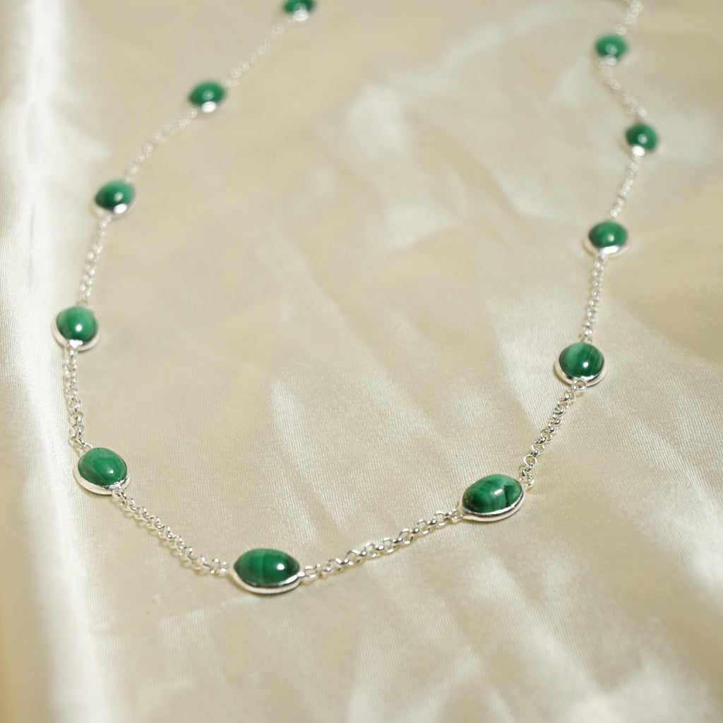 Necklace with green beads on a beige fabric background