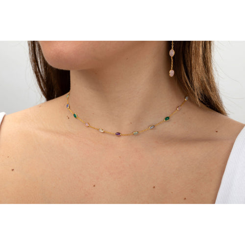 Necklace with multicolored beads worn by a person on a plain background