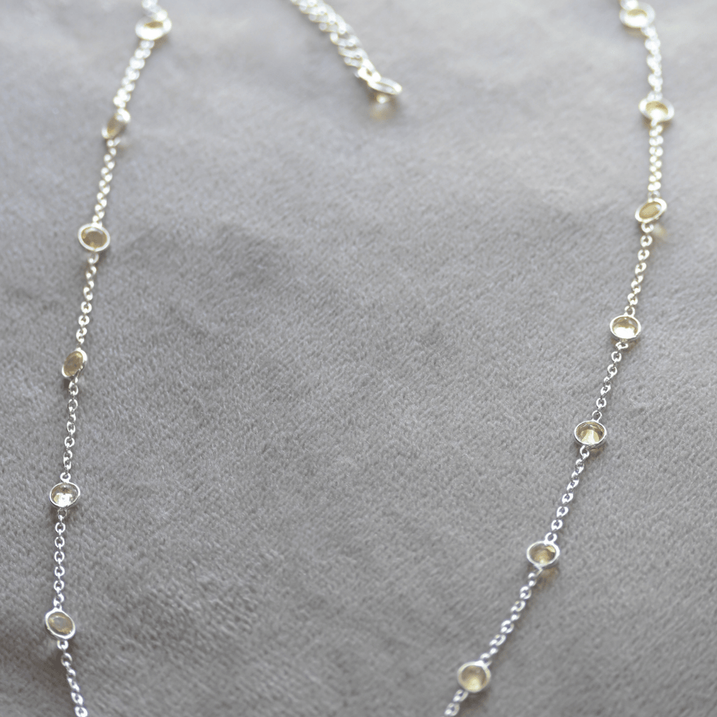 Silver necklace with small beads on a gray surface