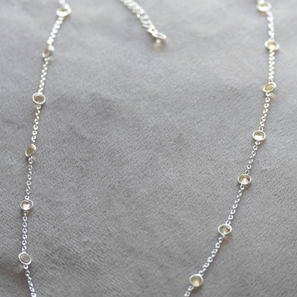 Silver necklace with small beads on a gray surface