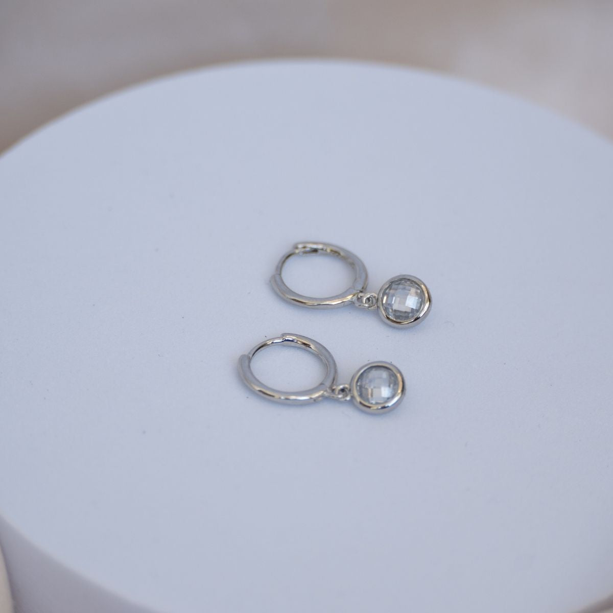 Huggy earrings with dangly cubic zirconia stones