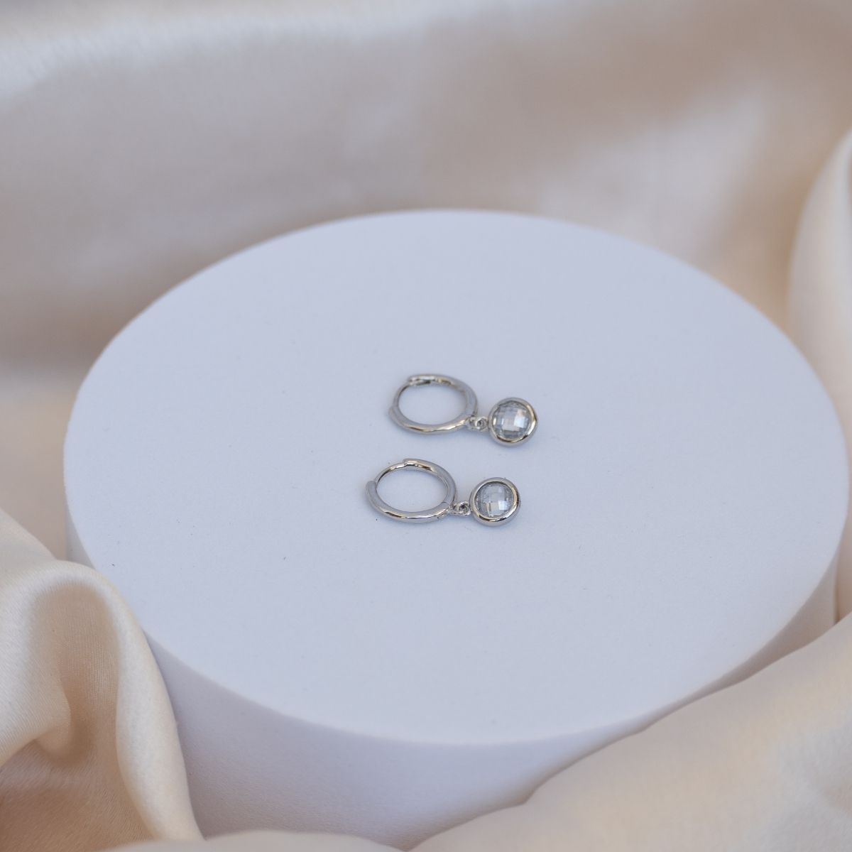 Huggy earrings with dangly cubic zirconia stones