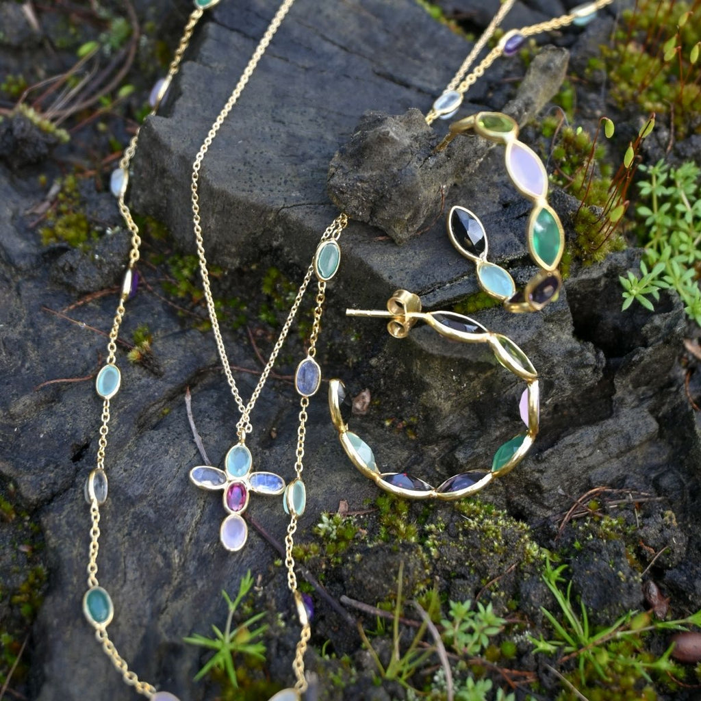Jewelry set with necklaces and earrings on a stone surface