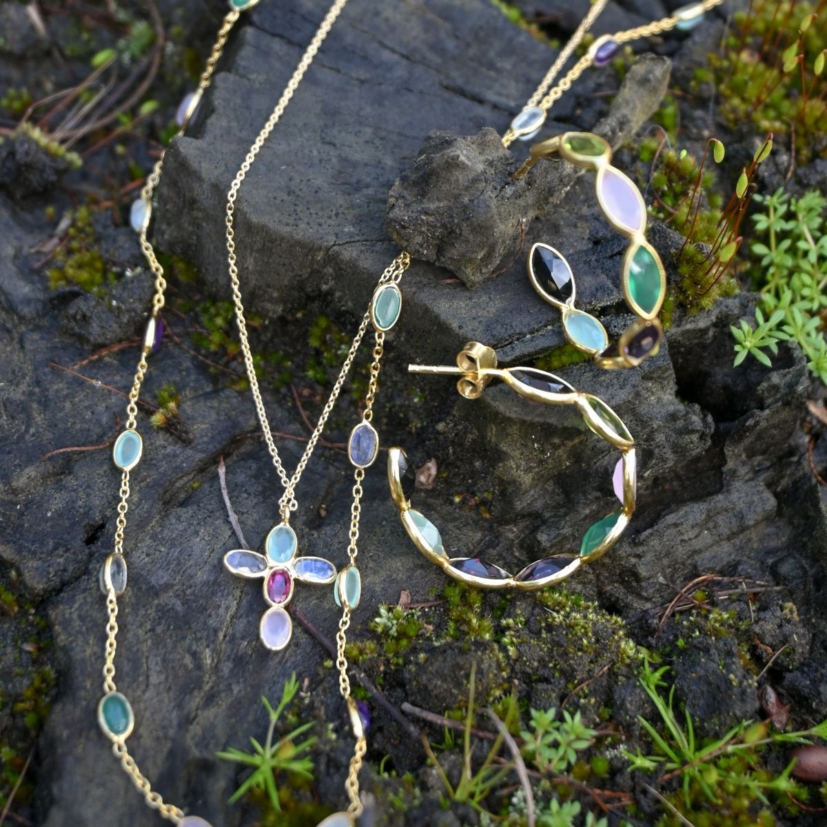 Jewelry set with necklaces and earrings on a stone surface