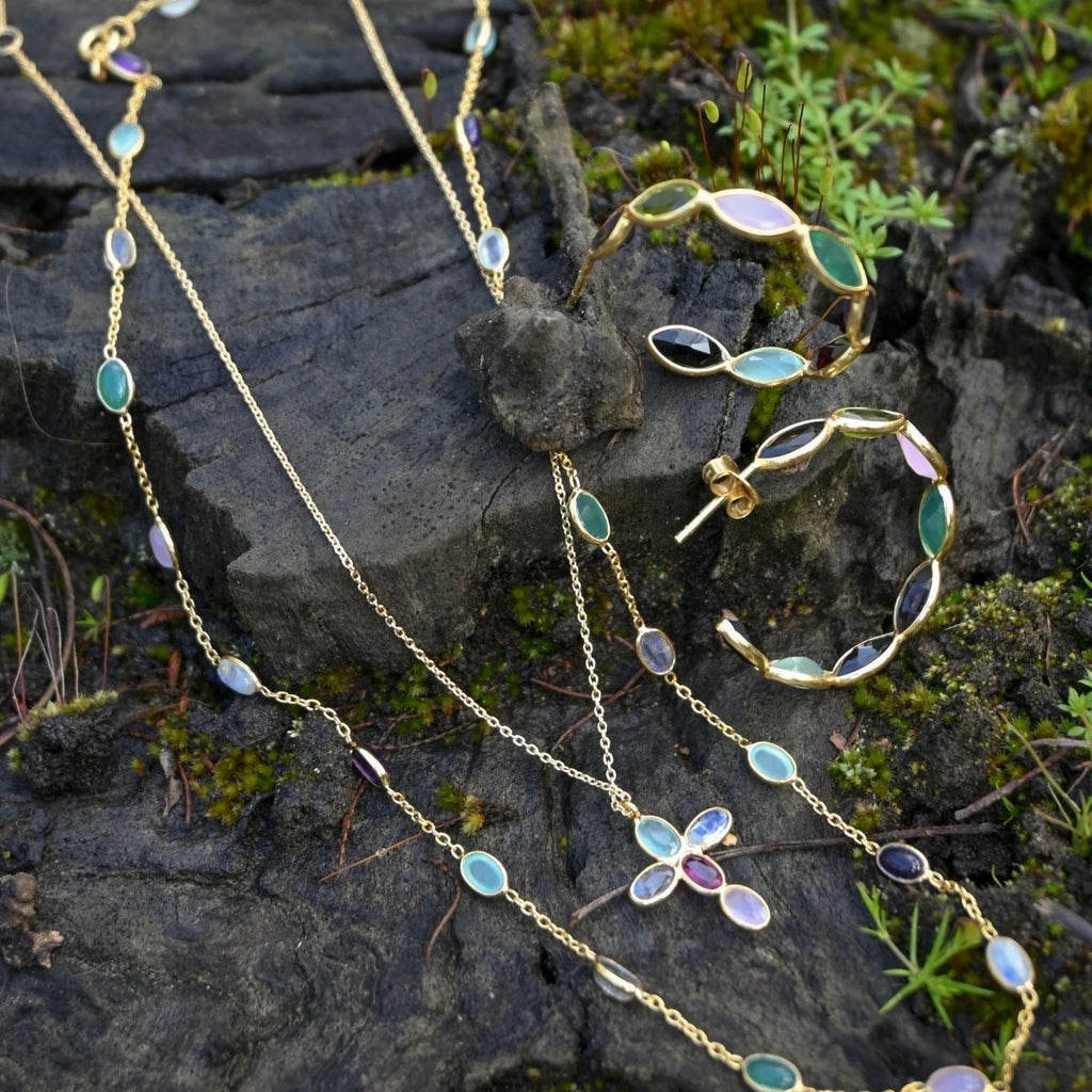 Jewelry set with necklaces and a bracelet on a stone surface
