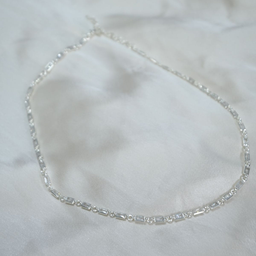 Silver bracelet on a white fabric background