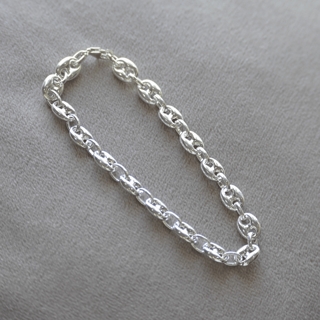 Silver chain bracelet on a gray background