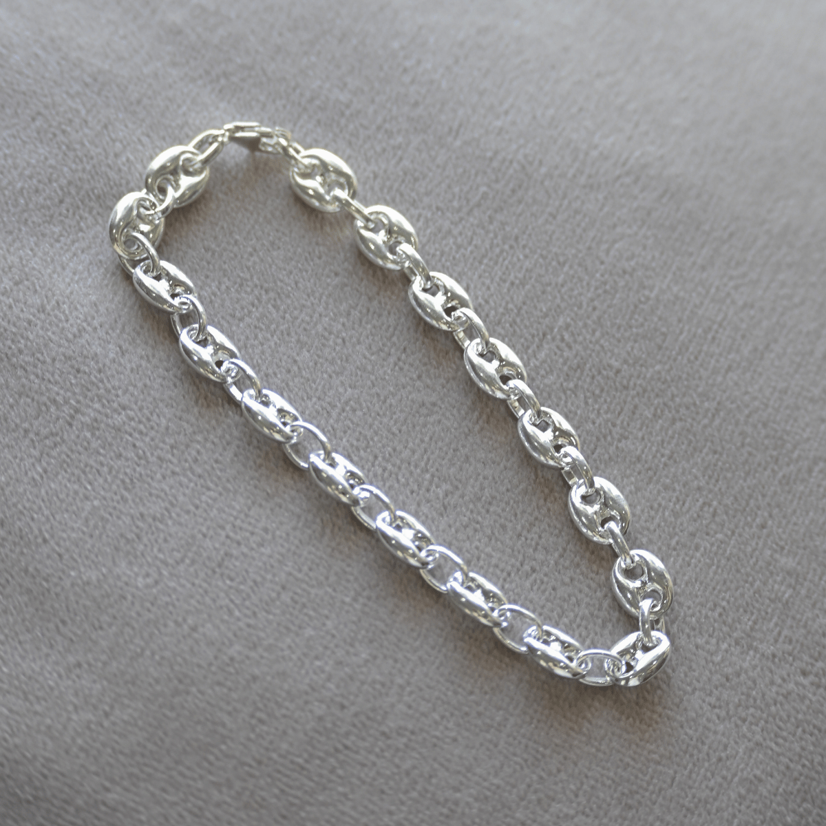 Silver chain bracelet on a gray background