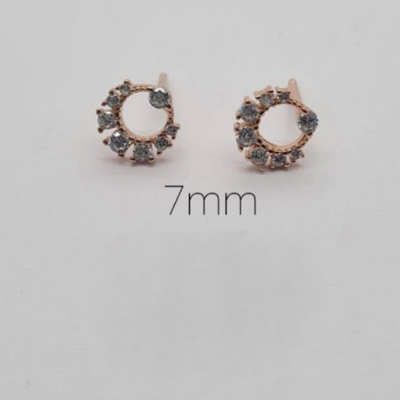 A pair of rose gold circle stud earrings with cubic zirconia, displayed against a white background with the measurement '7mm' shown in the center.