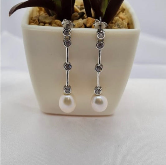 Modern looking long drop earrings with freshwater pearls on end